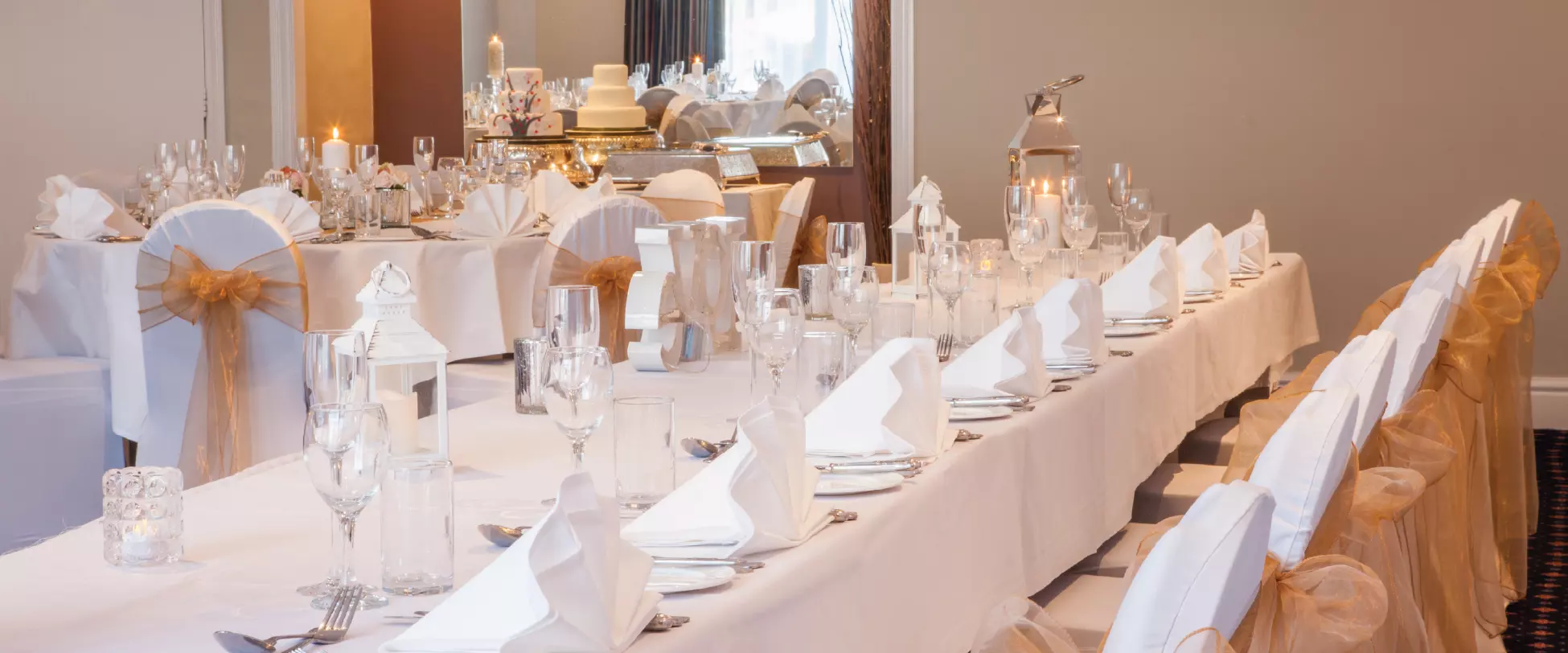 A wedding table set up with glassware, flowers and candles.